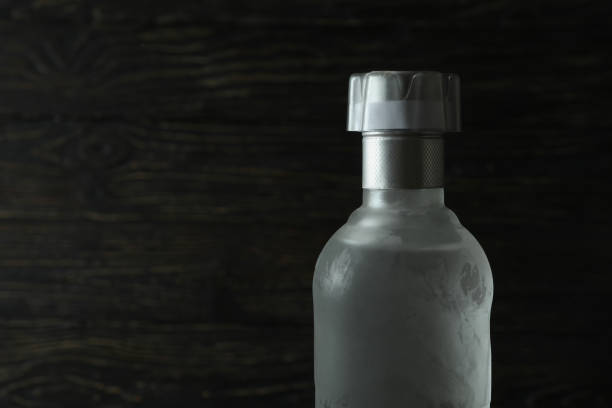 istock Blank bottle of vodka on wooden background, space for text 1302649219