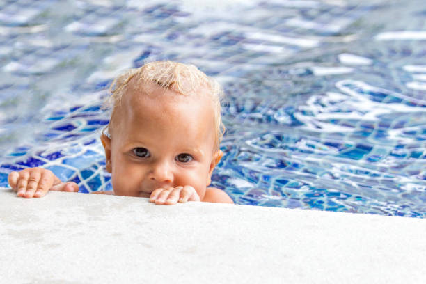 söt baby simmar i en pool i solig sommardag - baby swim under water bildbanksfoton och bilder
