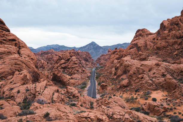 strada vuota a valley of fire, nevada - arid climate asphalt barren blue foto e immagini stock