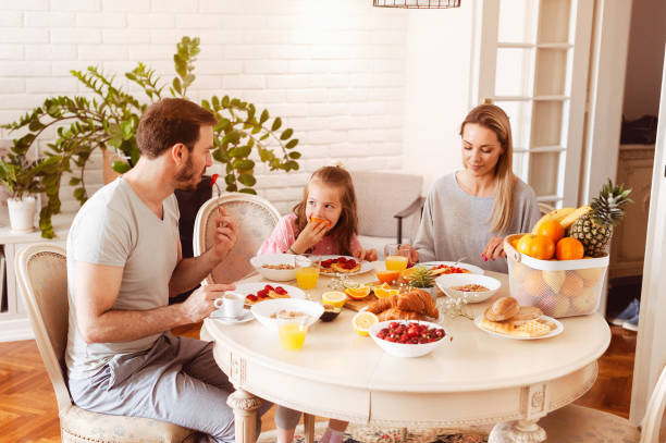 istock Young family eating healthy breakfast at a dining table 1302650476