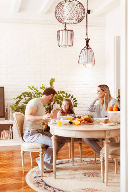 istock Young family eating healthy breakfast at a dining table 1302650482