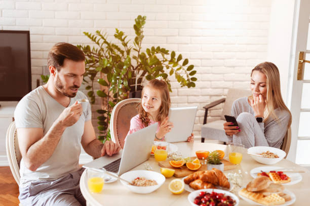 istock Family using technology at a dining table in the morning 1302650507