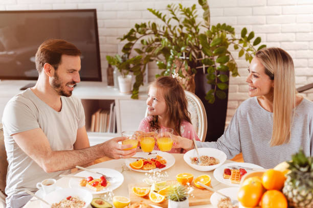 istock Young family eating healthy breakfast at a dining table 1302650512