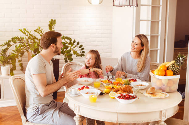 istock Young family eating healthy breakfast at a dining table 1302650517