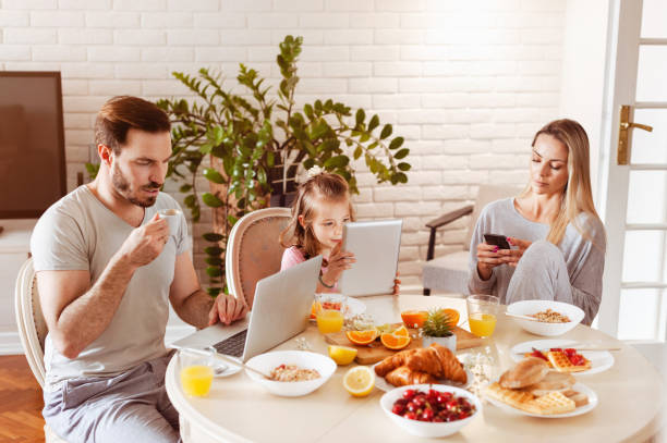istock Family using technology at a dining table in the morning 1302650559