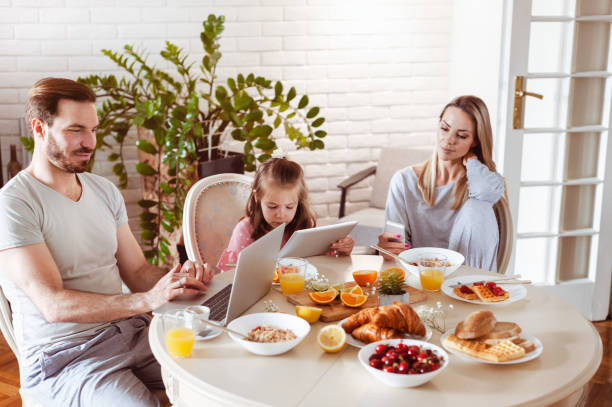 istock Busy disconnected Family using technology at a dining table in the morning 1302650560