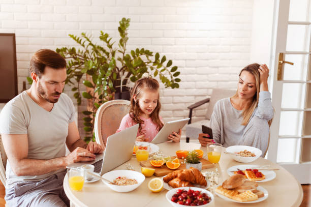 istock Busy disconnected Family using technology at a dining table in the morning 1302650568