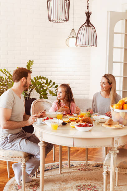 istock Young family eating healthy breakfast at a dining table 1302650583