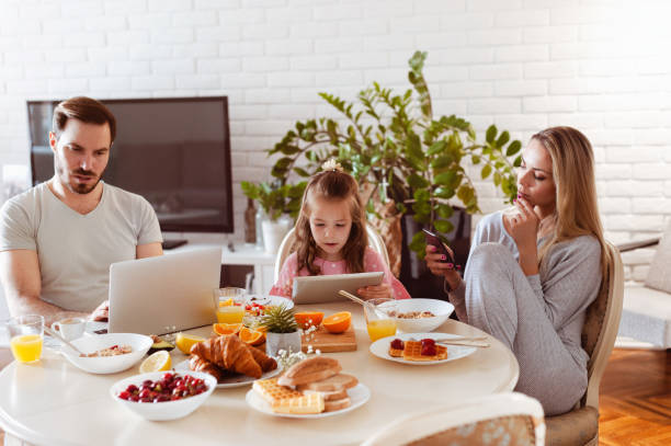 istock Busy disconnected Family using technology at a dining table in the morning 1302650724