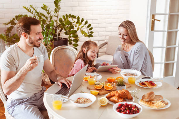 istock Family using technology at a dining table in the morning 1302651001