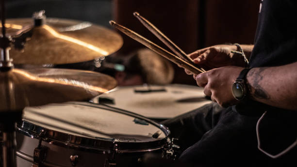 baterista segurando baquetas ao lado de um kit de bateria prestes a tocar - rock bass - fotografias e filmes do acervo