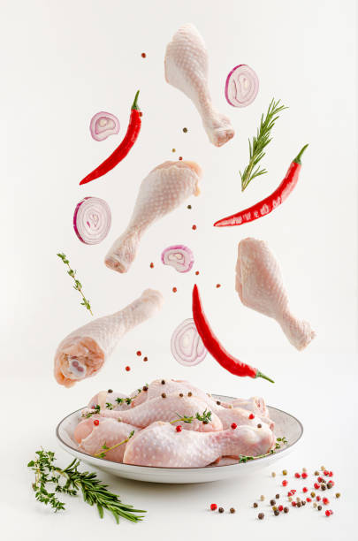 le cosce di pollo crudo marinate piccanti o la levitazione delle bacchette. concetto di cibo volante. - chicken food raw meat foto e immagini stock