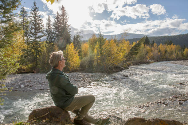 istock Hiker relaxes by sunny river front in the morning 1302652906