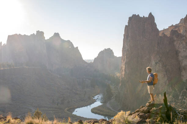 istock Man hikes along sunny mountain ridge in the morning 1302653525