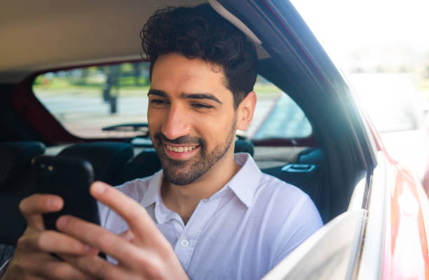istock Businessman using mobile phone in car. 1302653928