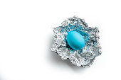 Easter egg in silver foil on a white background