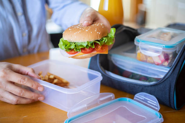 istock Woman hands holding hamburger 1302655755