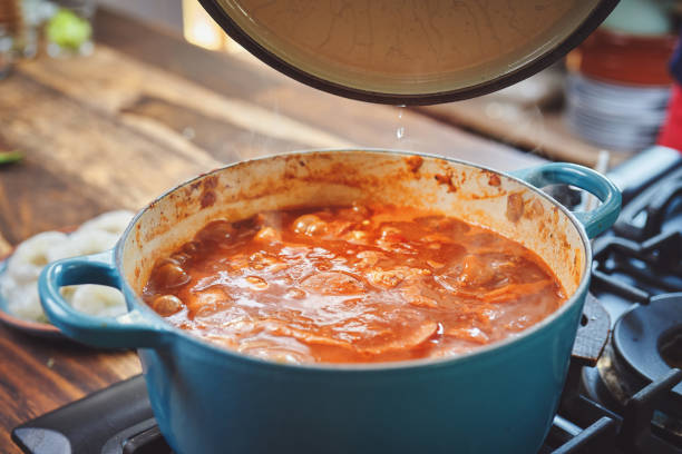 주철 냄비에 케이준 스타일 치킨, 새우와 소시지 잠발라야 준비 - jambalaya 뉴스 사진 이미지