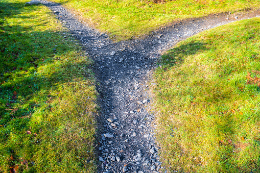 A gravel path diverging in two different directions.