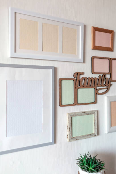 istock White wall with set of different empty vertical and horizontal frames to create family photo gallery 1302658522