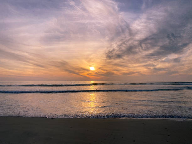 istock Colorful orange ocean beach sunset with deep clouded sky 1302658582