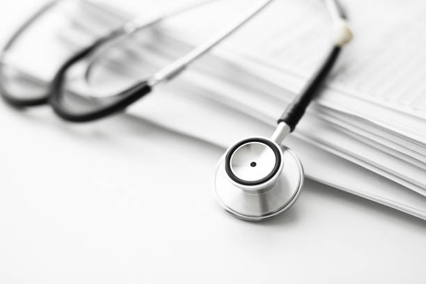 istock Stack of report medical documents and stethoscope isolated on white background 1302661357