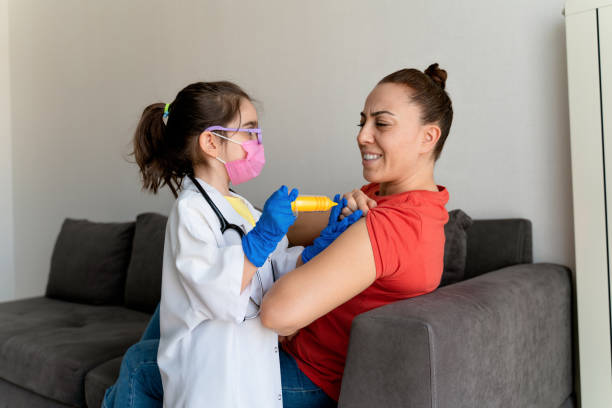 istock Vaccinated mother gives a pain expression to her face while playing games with her daughter 1302662877