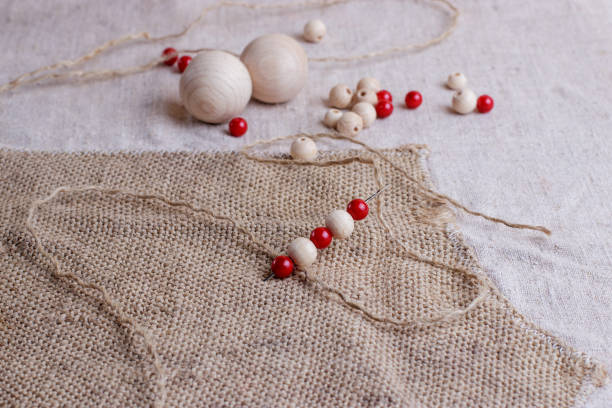 istock Red and white beads of different sizes are strung on the needle. 1302665217