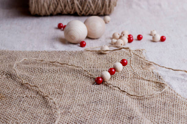 istock Red and white beads of different sizes are strung on the needle. 1302665227