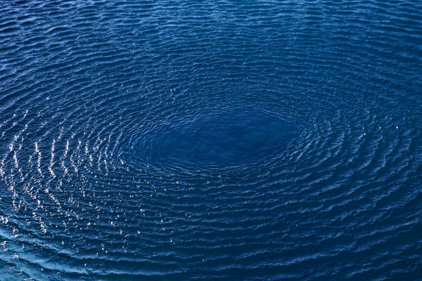istock Splash: concentric circle waves on blue fresh sea water 1302666336