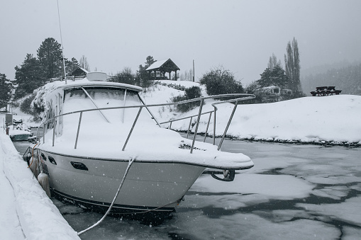 snow covered boat in marina that is iced over on a cold winter day on Vancouver Island, Canada