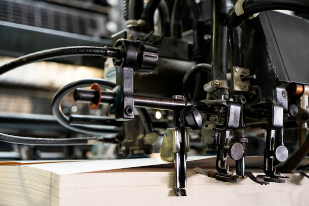 istock Offset printing machine feeder transfer metallic paper through the feeding table to the printing unit 1302669270