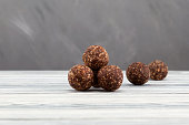 Energy balls with almonds, sweets proper nutrition homemade. Made from dates, apricots, pine nuts and prunes, with honey.  Grey background, selective focus, copy space