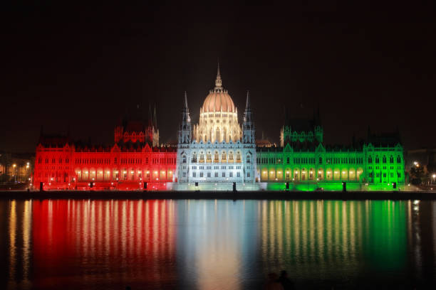 ドナウ銀行の国色で照らされた夜のハンガリー議会 - editorial eastern europe europe reflection ストックフォトと画像