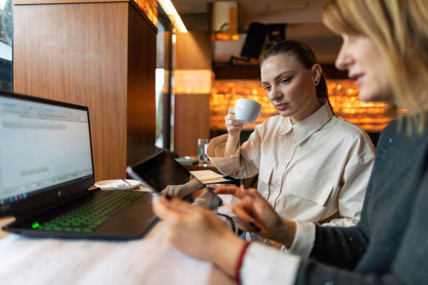 istock Two female business associates talking about project while sitting in cafe 1302670585