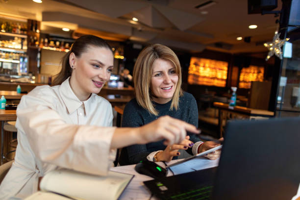 istock Two businesswoman working on new project using laptop in cafe 1302670666