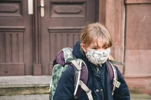 istock girl with schoolbag wearing a mask 1302672096