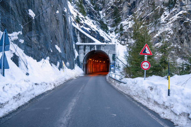 istock Illuminated tunnel along a mountain road in winter 1302673381