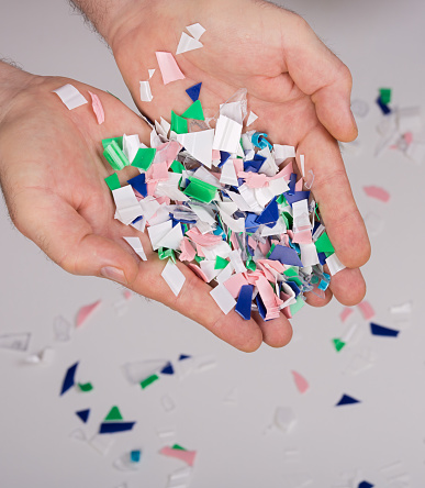 shredded plastic packaging held in hands