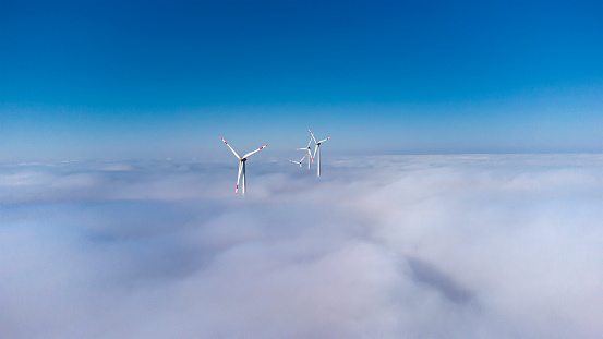 Wind turbines over the fog - aerial view