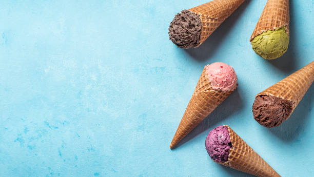 istock ice cream scoops in cones with copy space on blue 1302675592