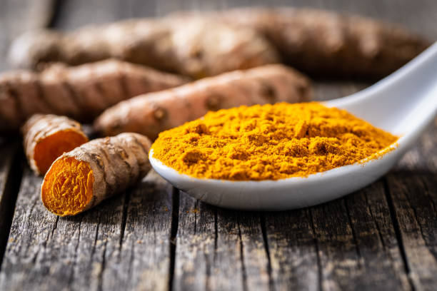 istock Indian turmeric powder and root. Turmeric spice. Ground turmeric. 1302675630