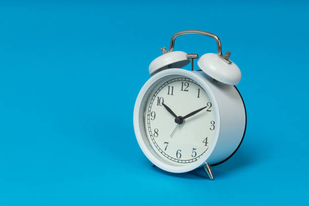 istock Retro alarm clock on blue background. Old fashioned alarm clock 1302675753