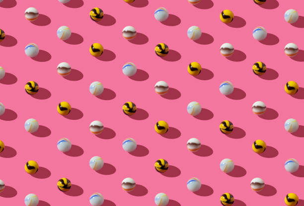 istock Pattern with vintage glass marbles in playful colors on a pink background. 1302676572
