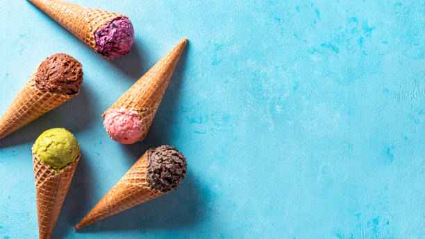 primicias de helado en conos con espacio de copia en azul - ice cream fotografías e imágenes de stock