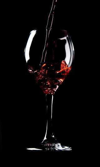 Smoke swirls fading from a red wine glass isolated on white background with space for text and images.Wine tasting concept.