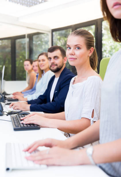 istock Side view of row of active people working 1302680262