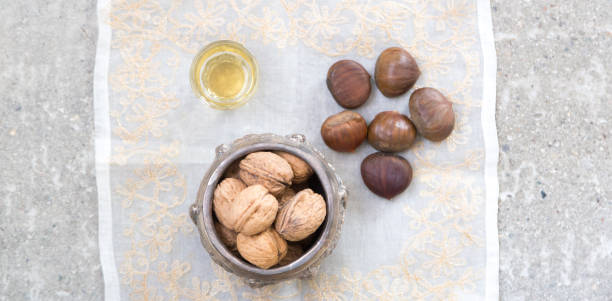 walnuts, chestnuts and a golden liquor glass on a concrete surface - whisky liqueur glass alcohol bottle imagens e fotografias de stock