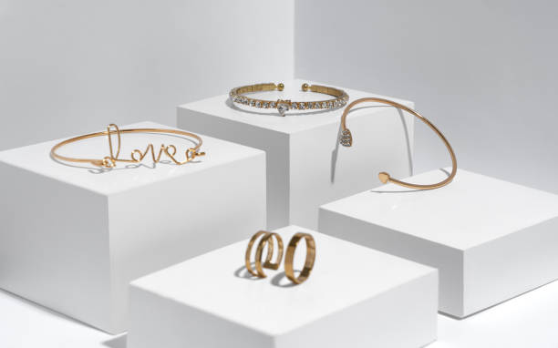 istock Golden bracelets and rings on white boxes with copy space 1302683556