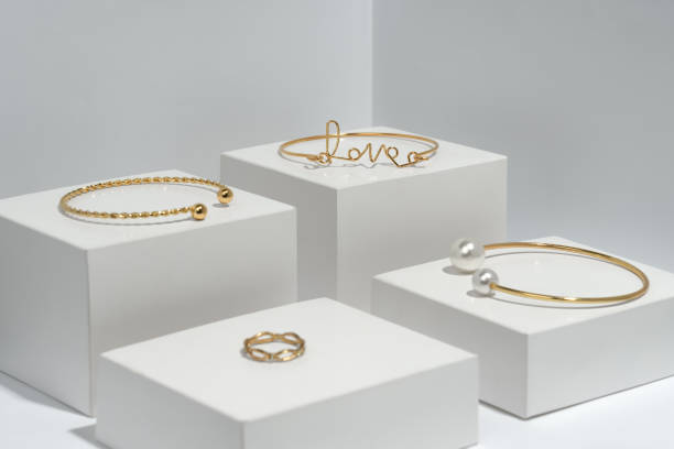 istock Golden bracelets and ring on white cubes eith copy space 1302683558